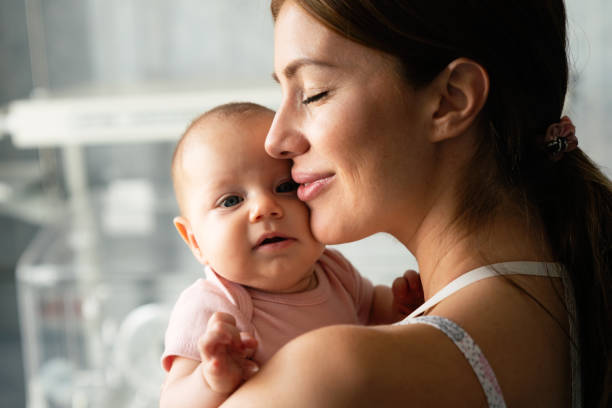 Happy cheerful family concept. Mother and baby kissing, laughing and hugging